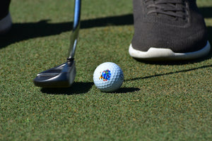 Action image of a Saintnine golf ball being putt into a hole.